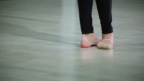 Close-up feet of ballerina in pointe performs dance ballet elements in gym Stock Footage 103434779