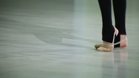 Close-up feet of ballerina in pointe performs dance ballet elements in gym Stock Footage 103434793