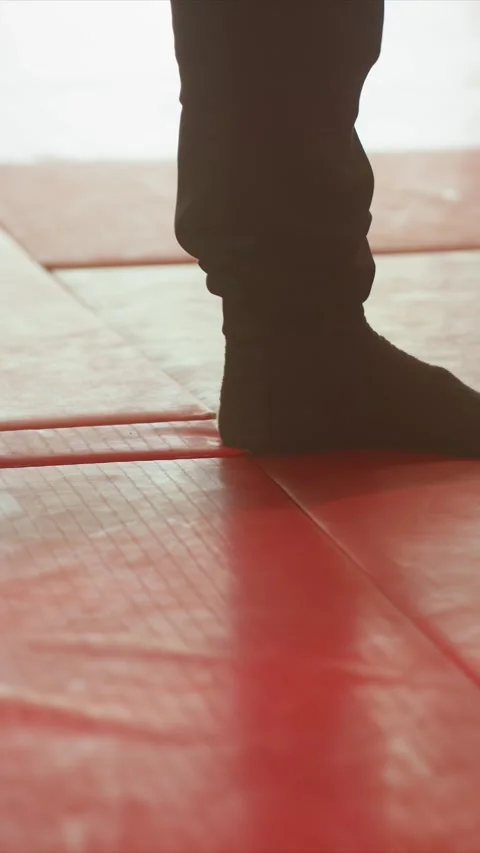 Close up feet in black socks performing footwork movements across red gym mats Stock Footage 343082018