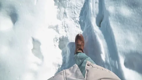 A close-up of feet in brown boots walking on fresh snow. Snowy terrain is Vidéo 337111101