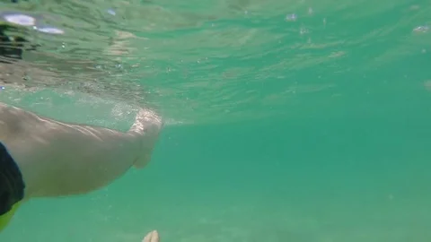 Close up of feet floating in ocean man relaxing in clear blue tropical water on Stock Footage 85290196