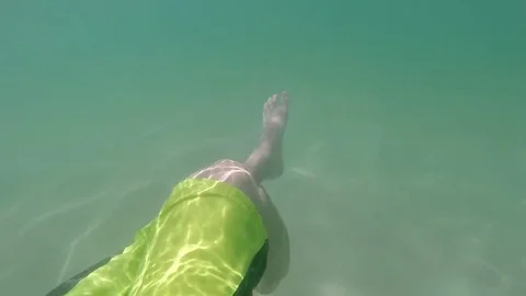 Close up of feet floating in ocean man relaxing in clear blue tropical water on Stock-Footage 85402162