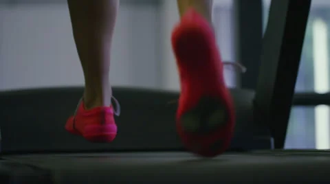 Close up of feet running on a treadmill in slow motion Stock Footage