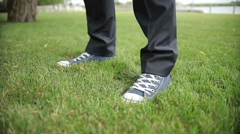 Close up, the feet  in sneakers stand down on the grass Stock Footage 45794609