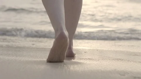 Close up of feet walking into an ocean at sunset Stock Footage 108520523