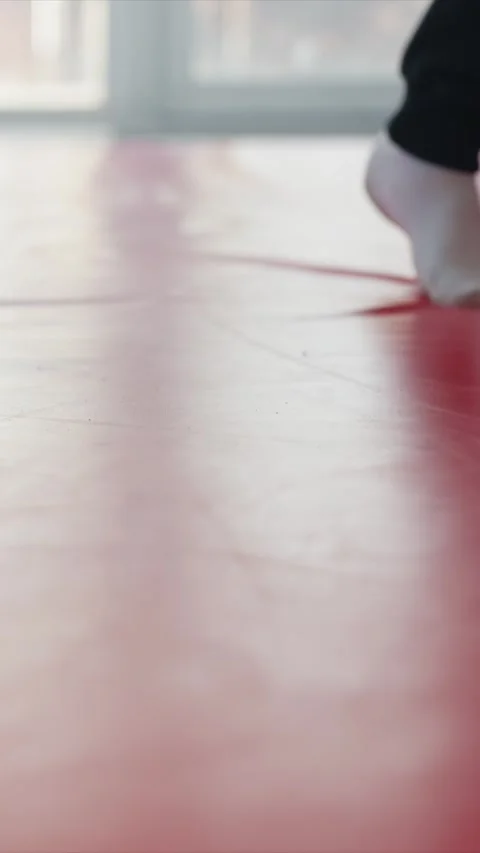 Close up of feet in white and black socks stepping on red padded floor indoors Stock Footage 343080800