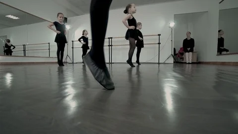 Close-up feets of dancer in black tutu are moving altogether. Kids are warming Video stock 113529502