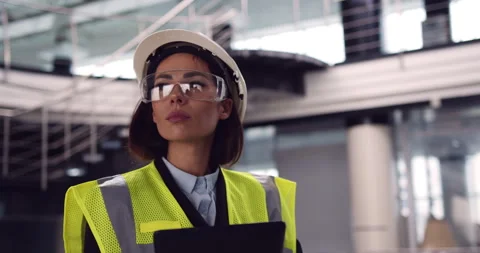 Close up of female architect standing inside empty office center holding a Video stock 153168993