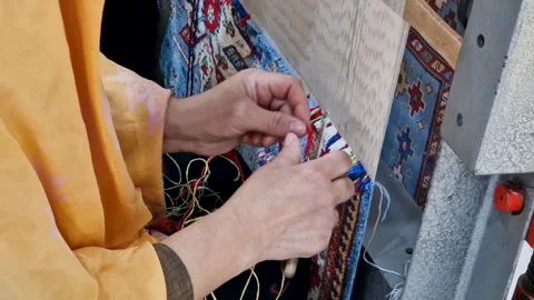 Close-up of a female artisan's hands knitting yarn and weaving an authentic.. Stockbeeldmateriaal 335981590