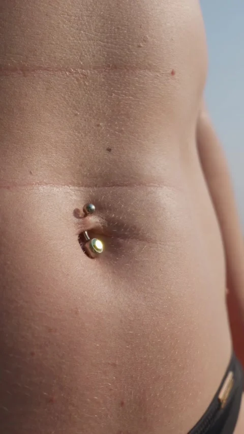 Close-Up of Female Belly Piercing in Sunlight During Summer Beach Day Vidéo 343562612