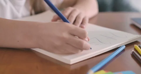 Close-up of female Caucasian hands solving math problem in the exercise book Stock Footage 120505079