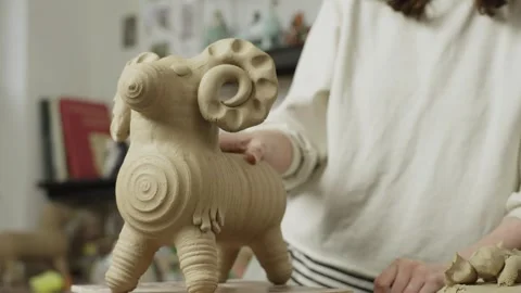 Close-up of a female ceramist adding small details to a figurine. Stock Footage 253987800