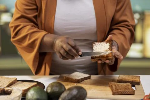 Close up of female chef using cream cheese spread on a bread slice Stock Photos