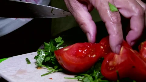 Close-up of a female chef's hands cutting delicious tomatoes and herbs Stock Footage 341765076