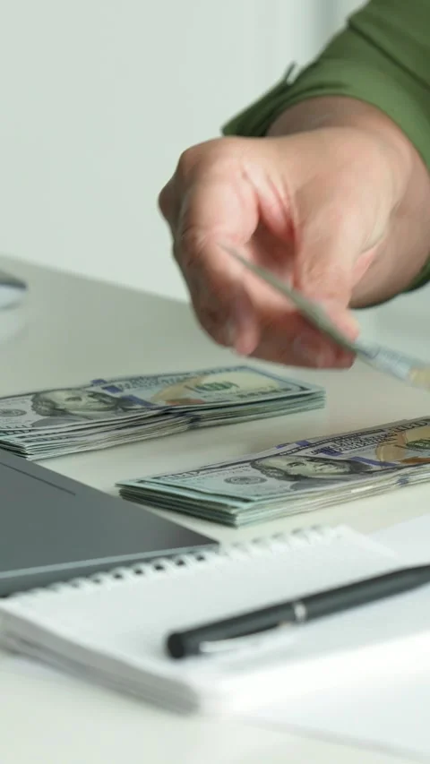 Close up female counting one hundred dollar bills at work table Stock Footage 317629707