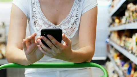 Close-up of female customer hands use phone in supermarket, texting Stock Footage 111965682