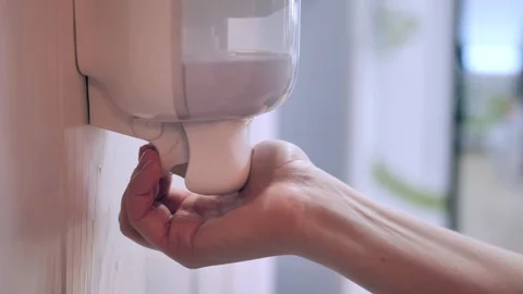 Close-up. Female customer using hand sanitizer In shop or supermarket. Stock Footage 128270679