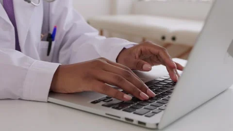 Close-up of female doctor hands typing on a laptop computer at her desk. Stock Footage 317618207