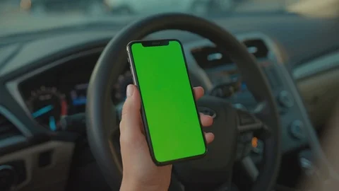 Close-up of female driver browsing news on vertical greenscreen mobile fist Stock Footage 117548853