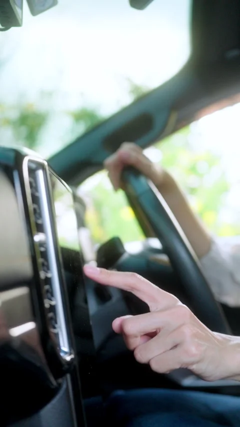 Close-up of female driver's hand touching the screen of a infotainment system Stock Footage 345330287