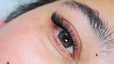 Close up of female eye with eyelash extensions in beauty salon Stock Footage 329012103