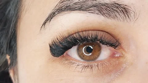 Close up of female eye with eyelash extensions in beauty salon Stock Footage 329012104