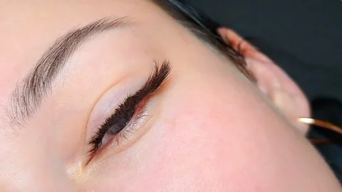Close up of female eye with eyelash extensions in beauty salon Stock Footage 329012177
