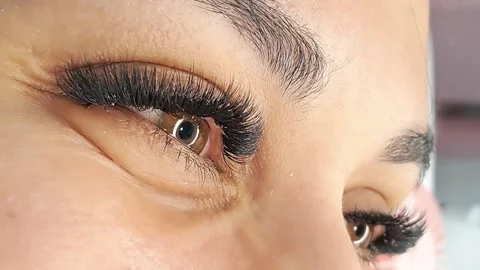Close up of female eye with eyelash extensions in beauty salon Stock Footage 329012178