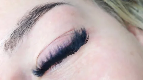 Close up of female eye with eyelash extensions ,eyelash extension procedure Stock Footage 329742796