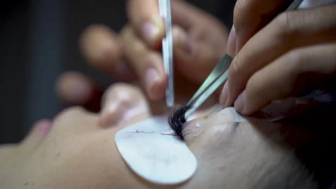 Close up of female eye with long lashes during eyelash extension procedure Stock Footage 332305343