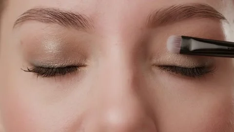 Close-up of female eyes with makeup in the process of applying eye shadow using Stock Footage 272956666