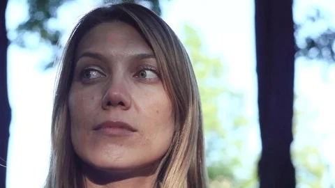 Close-up of a female face on a blurred background of green trees Stock Footage 77201202