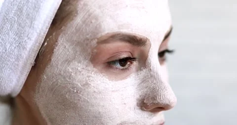 Close up of female face covered with white moisturising mask. Young brunette Stock Footage 142536741