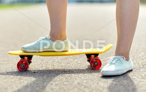 Close up of female feet riding short skateboard Stock Photos