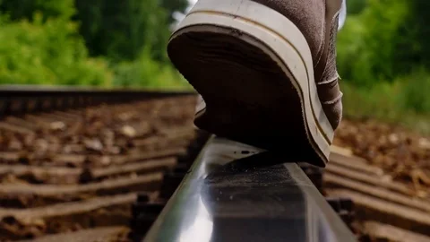 Close up of female feet in sneakers go on the web of the rail tracks. Hiking the Stock Footage