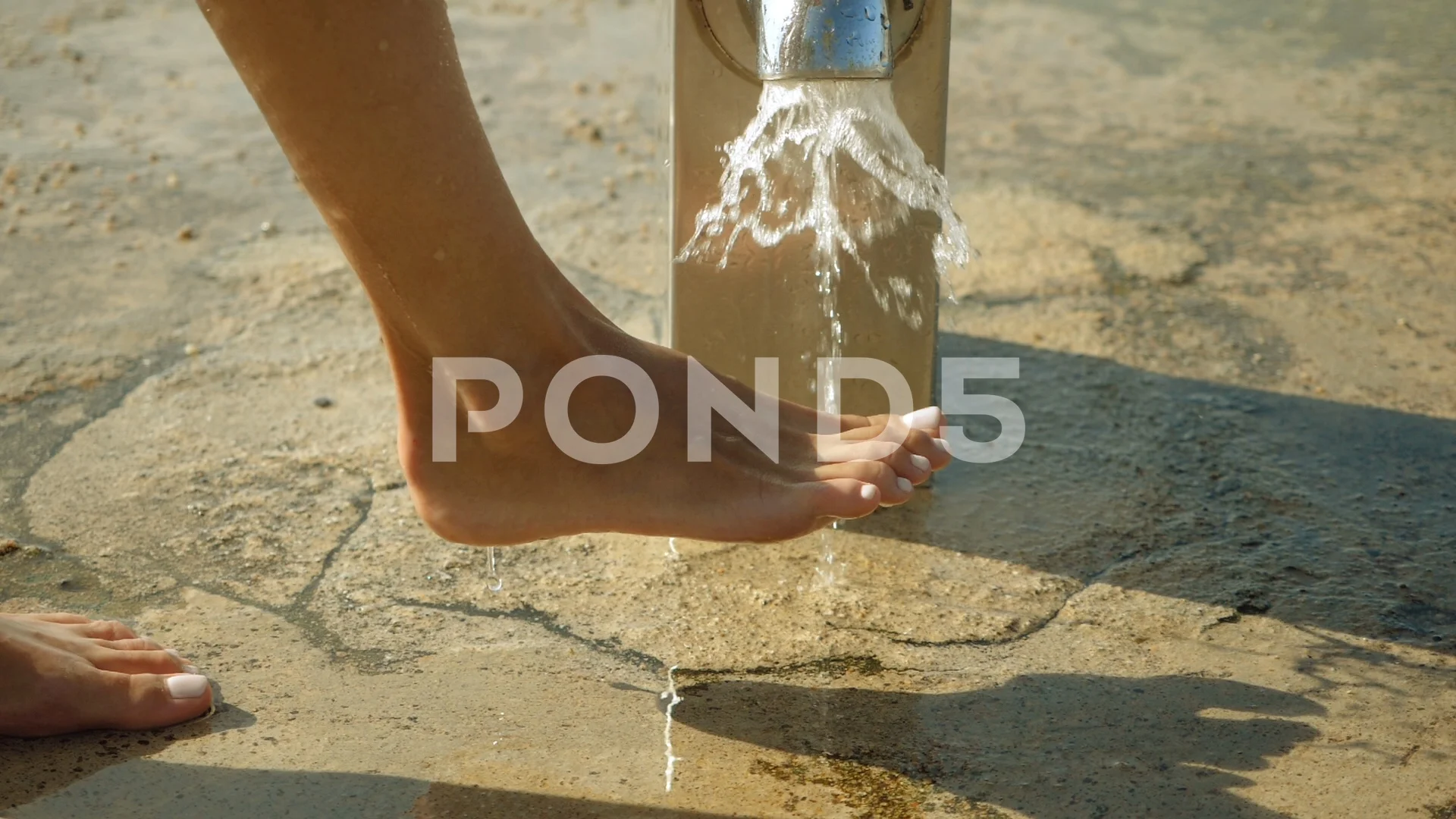 Close-up of female feet. Woman washing body under a shower at beach. Slow  mo. HD