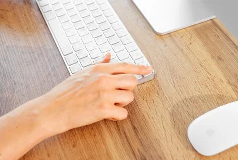 Close up of female finger using biometric Touch ID key on white keyboard. Unr 스톡 사진