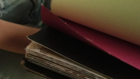 Close up of a female hand browsing fabric samples to choose material for roller Stock Footage 346688196