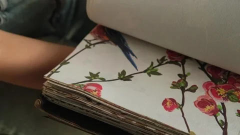 Close up of a female hand browsing fabric samples to choose material for roller Stock Footage 346688426