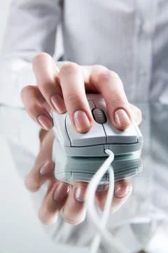 Close-up of female hand on computer or laptop mouse during work Stock Photos