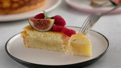 Close-up. Female hand with a fork broke off a piece of cheesecake with berries Stock Footage 147038952