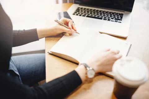 Close-up female hand making notes and notebook, student woman studying while Stock Photos