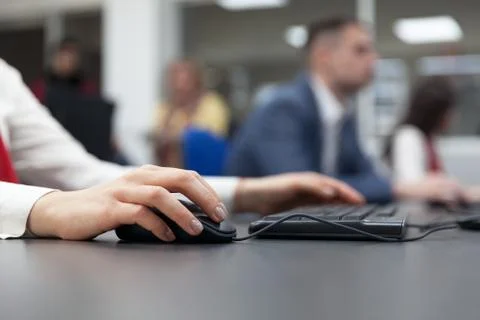 Close up of female hand on mouse while typing on keyboard Stock Photos