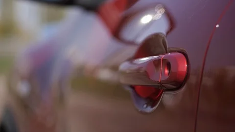 Close-up. Female hand opens the door of the red car. 4K Slow Mo Stock Footage 107828036