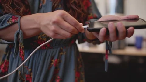 Close up, female hand plugging charger into phone 库存影片 213489448