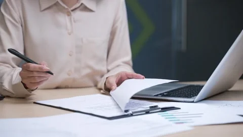 Close up of female hand signing documents at a desk at a workplace in a business Stock Footage 297280440