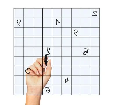 A close up of a female hand solving sudoku over white background 스톡 사진
