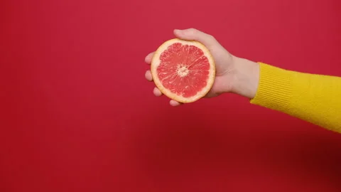 Close up of female hand squeezing fresh sliced grapefruit. Stock Footage 132527517