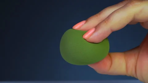 Close up of female hand squeezing makeup sponges, foundation sponge Stock Footage 245004593