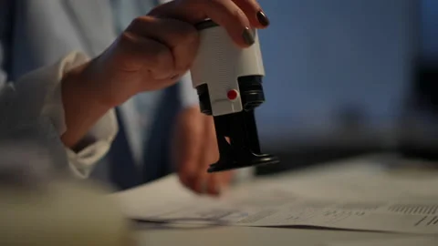 Close-up female hand stamping documents on table in office indoors Vídeos de archivo 205373853